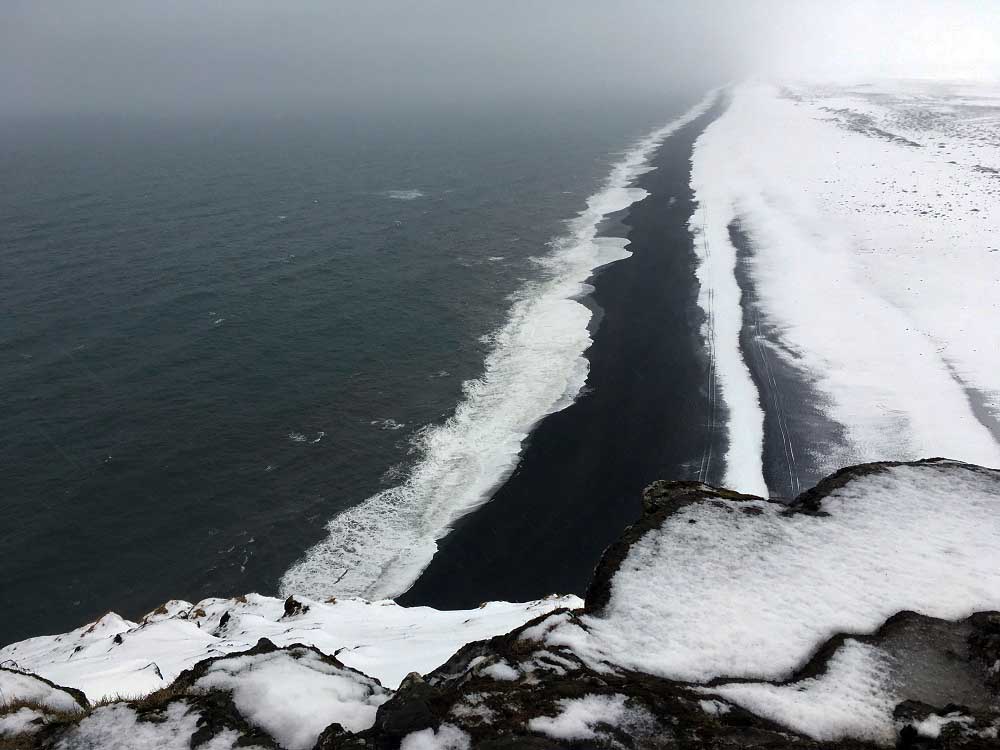 Blick vom Leuchtturm Dyrolaey auf den schwarzen Sandstrand und das tosende Meer sland Roadtrip Südküste gindeslebens.com © Thomas Mussbacher und Ines Erlacher