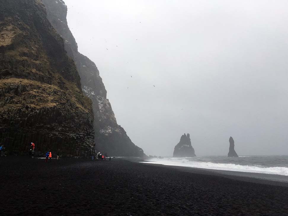 Schwarzer Sandstrand Reynisfjara und die schwarzen Felsnadeln (Dykes), die Reynisdrangar: Skessudrangur, Landdrangur und Langsamur. Der Legende nach sollen das 3 versteinerte Trolle sein. Island Roadtrip Südküste gindeslebens.com © Thomas Mussbacher und Ines Erlacher