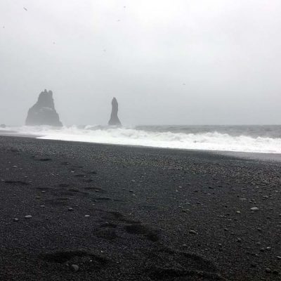 Schwarzer Sandstrand Reynisfjara und die schwarzen Felsnadeln (Dykes), die Reynisdrangar: Skessudrangur, Landdrangur und Langsamur. Der Legende nach sollen das 3 versteinerte Trolle sein. Roadtrip Islands Südküste gindeslebens.com © Thomas Mussbacher und Ines Erlacher