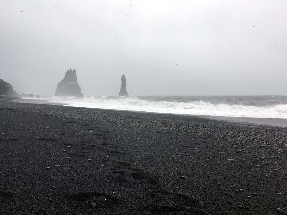 Schwarzer Sandstrand Reynisfjara und die schwarzen Felsnadeln (Dykes), die Reynisdrangar: Skessudrangur, Landdrangur und Langsamur. Der Legende nach sollen das 3 versteinerte Trolle sein. Roadtrip Islands Südküste gindeslebens.com © Thomas Mussbacher und Ines Erlacher